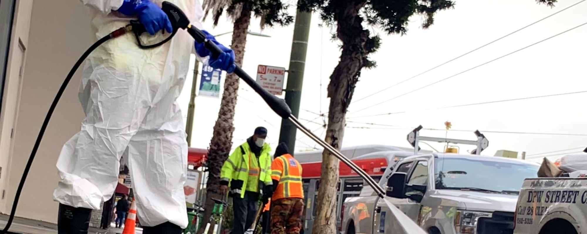 Picture of a worker power washing the sidewalk